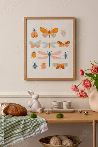 Canvas Print Warm composition of easter living room interior with mock up poster frame, wooden sideboard, vase with tulips, easter bunny, bread, beige cup, eggs and personal accessories