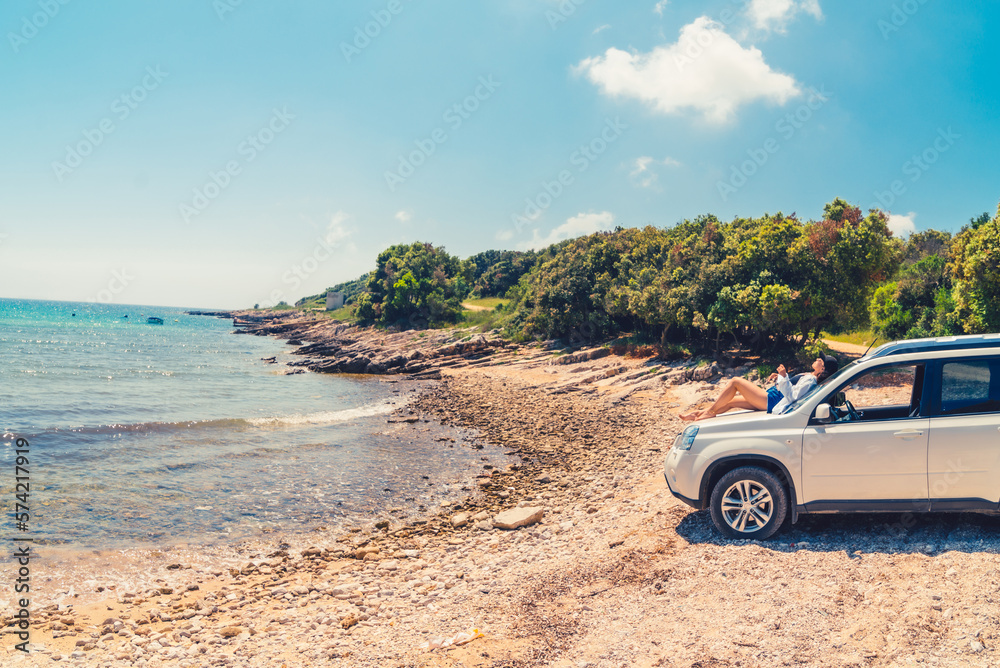 woman sitting on car hood at summer beach vacation concept woman sitting on car hood at summer beach vacation concept