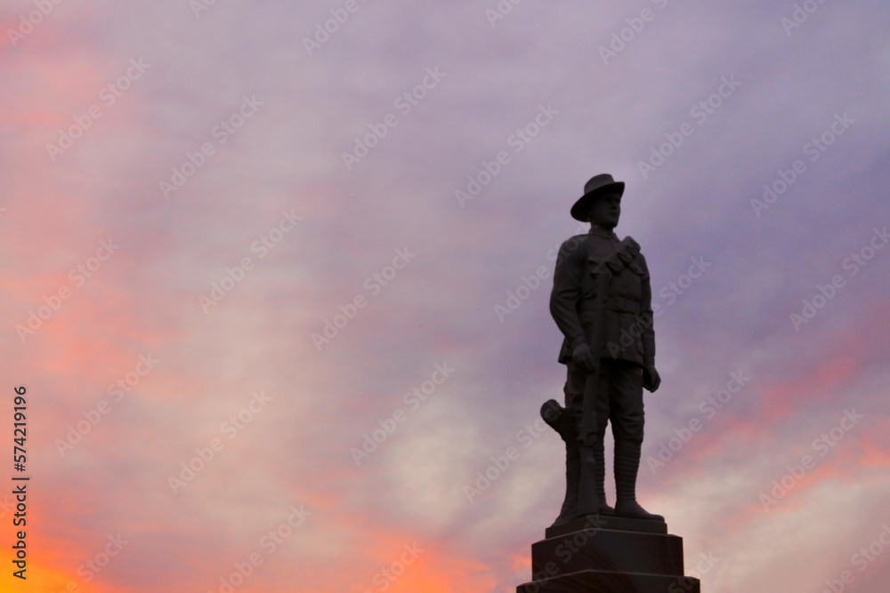 Silhouette of Aussie soldier keep silent against dramatic sunset sky with clouds in the outback of Queensland, Australia. Silhouette of Aussie soldier keep silent against dramatic sunset sky with clouds in the outback of Queensland, Australia.