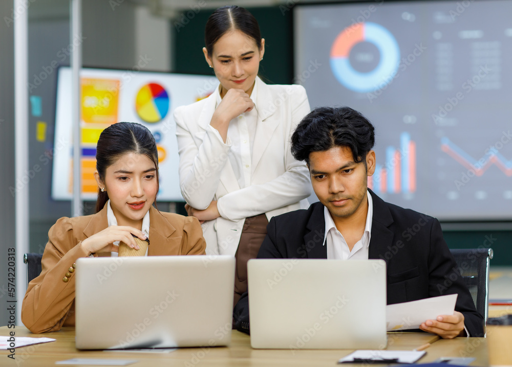 Millennial Asian Indian professional multinational male businessmen and female businesswomen in formal business suit standing sitting in meeting room mentoring brainstorming together with laptop Millennial Asian Indian professional multinational male businessmen and female businesswomen in formal business suit standing sitting in meeting room mentoring brainstorming together with laptop