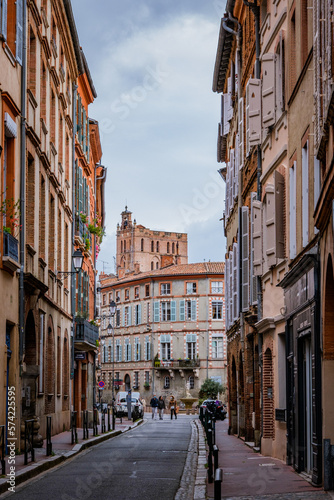 Beautiful facades with bricks in Perchepinte street and the Saint Etienne cathedral bell tower in Toulouse old town, in the south of France (Haute Garonne)