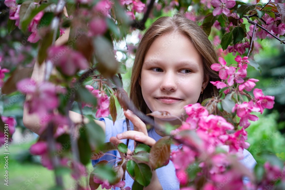 Spring face of a girl. Close-up portrait of a tender woman on the background of sakura flowers. Hanami festival in cherry blossom garden. Young blonde woman standing in sakura park. High quality photo Spring face of a girl. Close-up portrait of a tender woman on the background of sakura flowers. Hanami festival in cherry blossom garden. Young blonde woman standing in sakura park. High quality photo