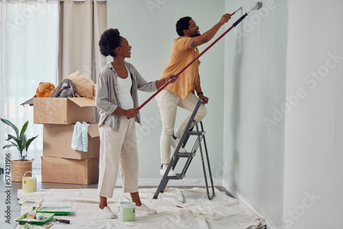 Fototapeta Naklejka Na Ścianę i Meble -  Painting, teamwork or black couple home renovation, diy or house remodel together with paintbrush or roller. Happy smile, woman and African man love working on wall with partnership or collaboration
