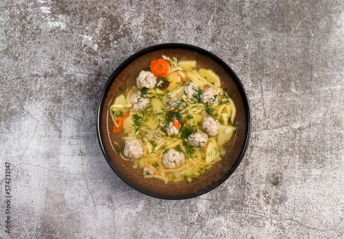 Homemade Meatballs noodle soup in a bowl on a dark background. Top view, flat lay