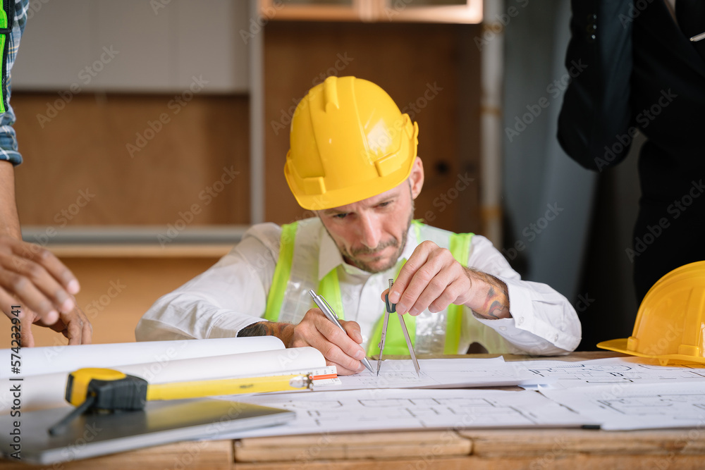 Team architect or engineer working on table use drawing tool on the paper plan for business architectural project at construction site. Team architect or engineer working on table use drawing tool on the paper plan for business architectural project at construction site.
