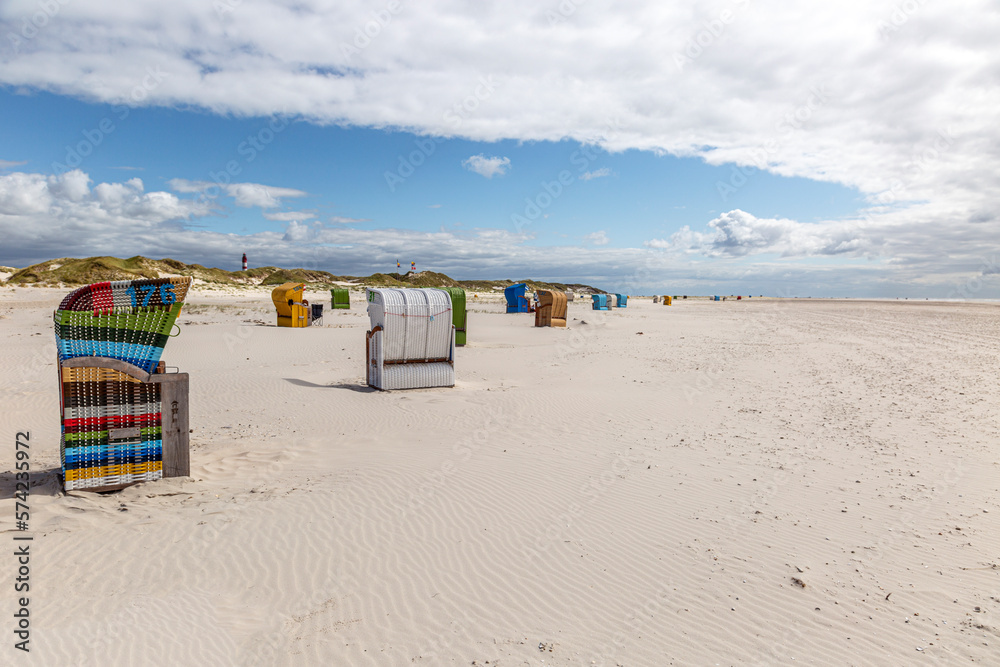 Viele bunte Strandkörbe am Sandstrand der Ostsee und Nordsee Viele bunte Strandkörbe am Sandstrand der Ostsee und Nordsee