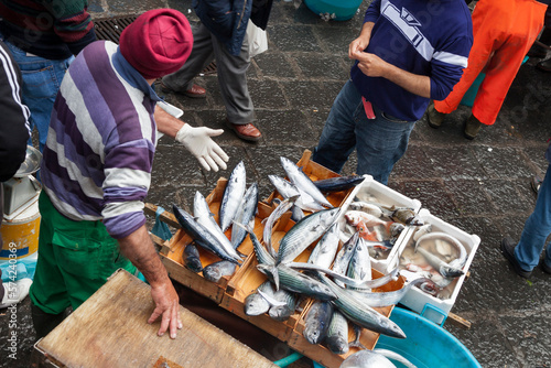 Fish vendor promoting its merchandise to potential customers in La Pescheria, the popular fish market of Catania, Sicily 