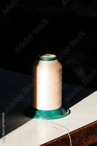 Nić krawiecka w słońcu. Warsztat krawca. 