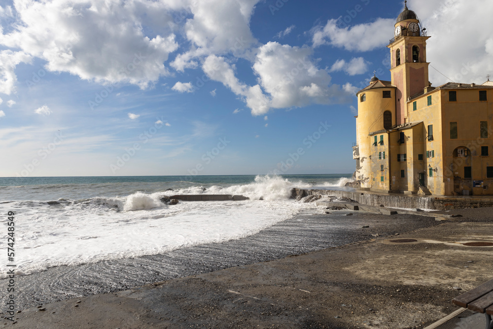Rough sea on the beach of Camogli and the Basilica of Santa Maria Assunta,  Genoa province, Italy.