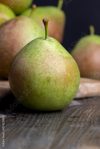 Whole ripe green pears on the board