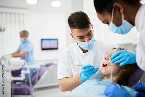 Teenage girl having teeth check-up during appointment with dentist.