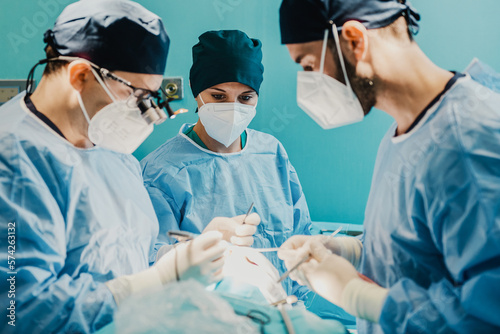 Medical doctors team operating patient in surgical room at hospital - Focus on nurse woman face