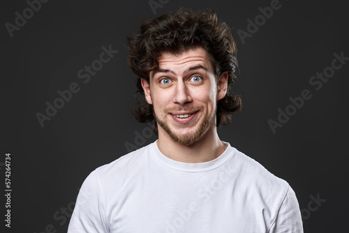 portrait of young smiling man on gray background