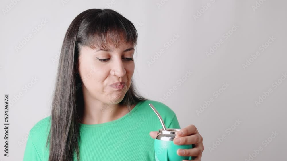 Latin American woman drinking mate, an Argentinian traditional drink and she likes it. Real people concept Latin American woman drinking mate, an Argentinian traditional drink and she likes it. Real people concept