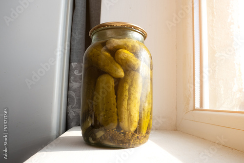 Homemade conservation of Salted pickled cucumbers preserved canned in glass jar.