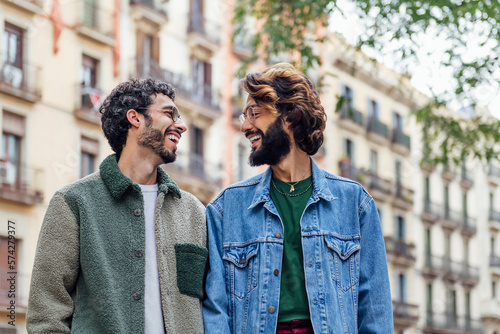 couple of gay men walking happy through the city laughing and looking into each other's eyes, concept of freedom and love between people of the same sex, copy space for text