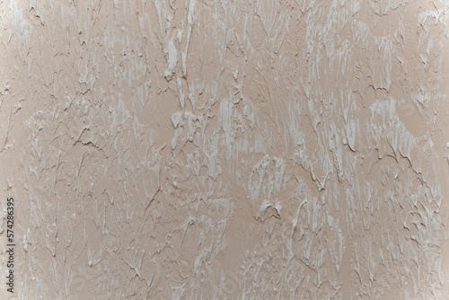 Decorative beige plaster concrete textured background. Decorative putty sample on the wall.