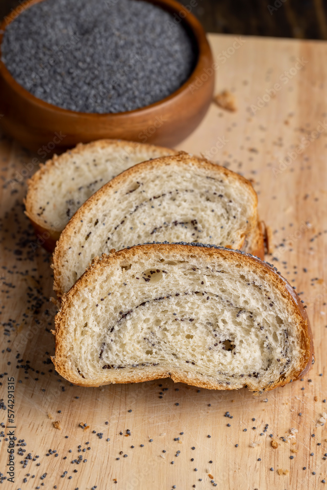 Poppy seeds and a bun with poppy seeds on the table Poppy seeds and a bun with poppy seeds on the table