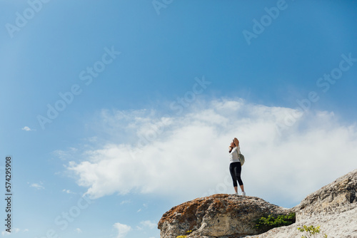 a woman standing on a mountain under a blue sky hiking journey