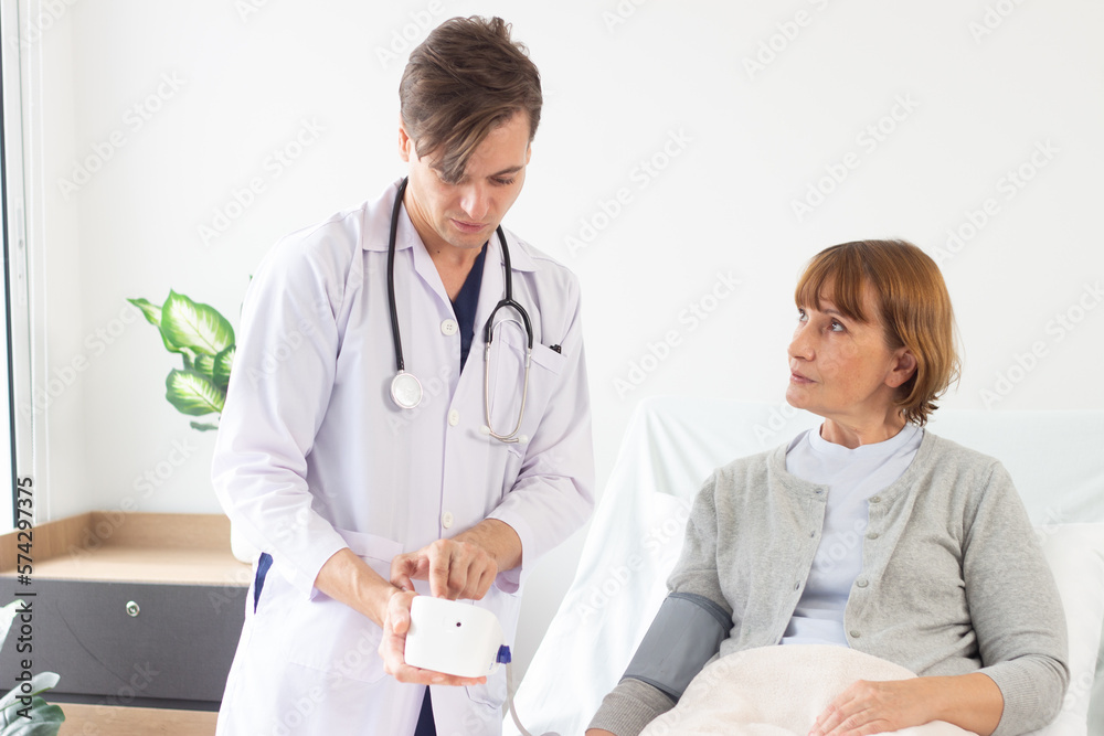 Fototapeta premium the doctor is examining the patient in the hospital. .Caucasian male doctor measuring blood pressure of female patient in hospital..