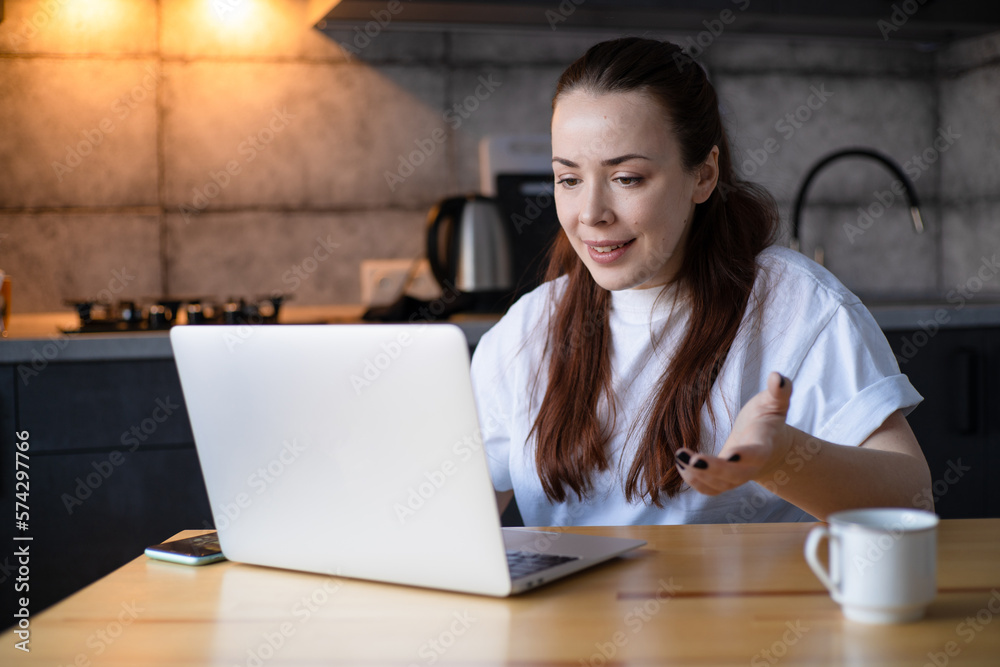 Work on the kitchen office. Remote work from home office. Young woman using laptop. Freelancer workplace at kitchen table. Distance education Work on the kitchen office. Remote work from home office. Young woman using laptop. Freelancer workplace at kitchen table. Distance education