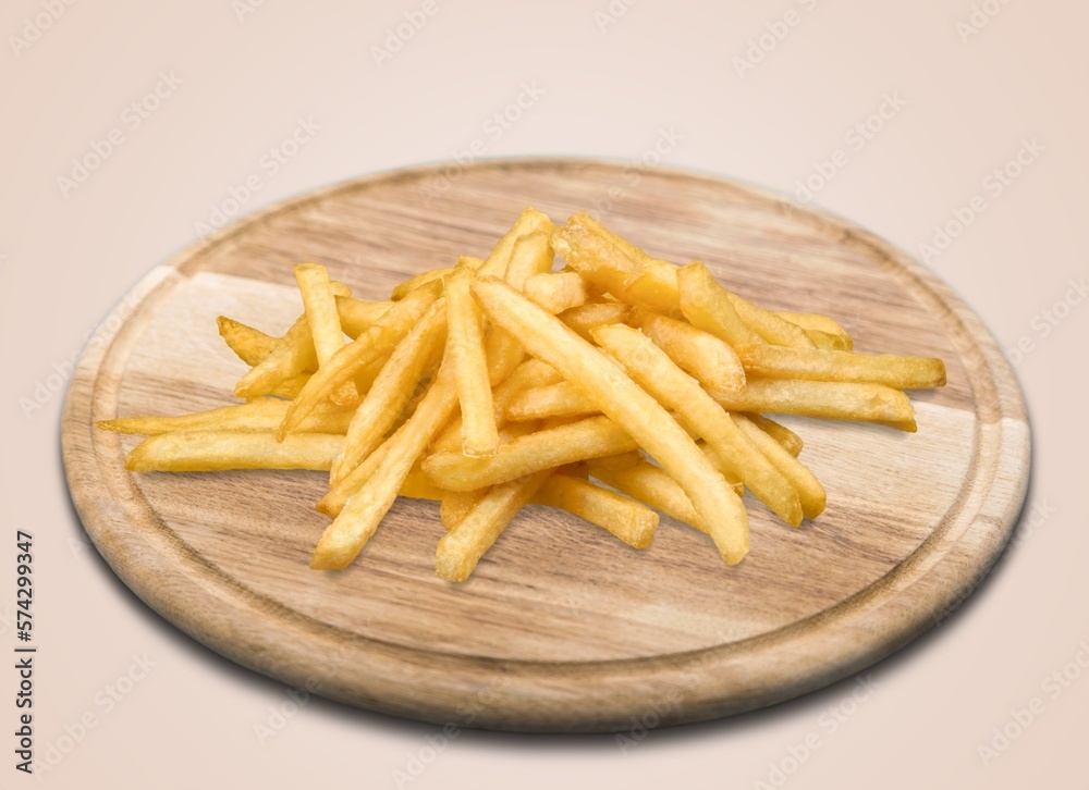 Freshly cooked tasty French fries on wooden board Freshly cooked tasty French fries on wooden board