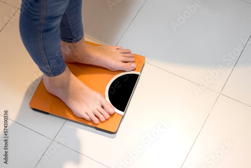 Closeup of a Woman weighing herself on a bathroom scale