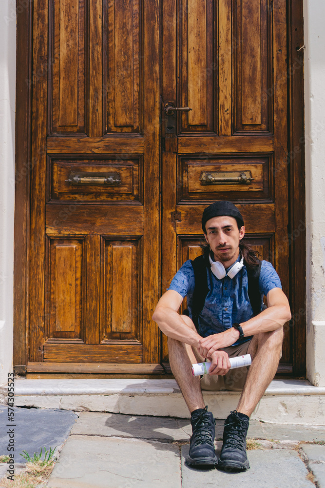 Young latin tourist looking at camera with city map in hand. Vertical photo. Copy space.