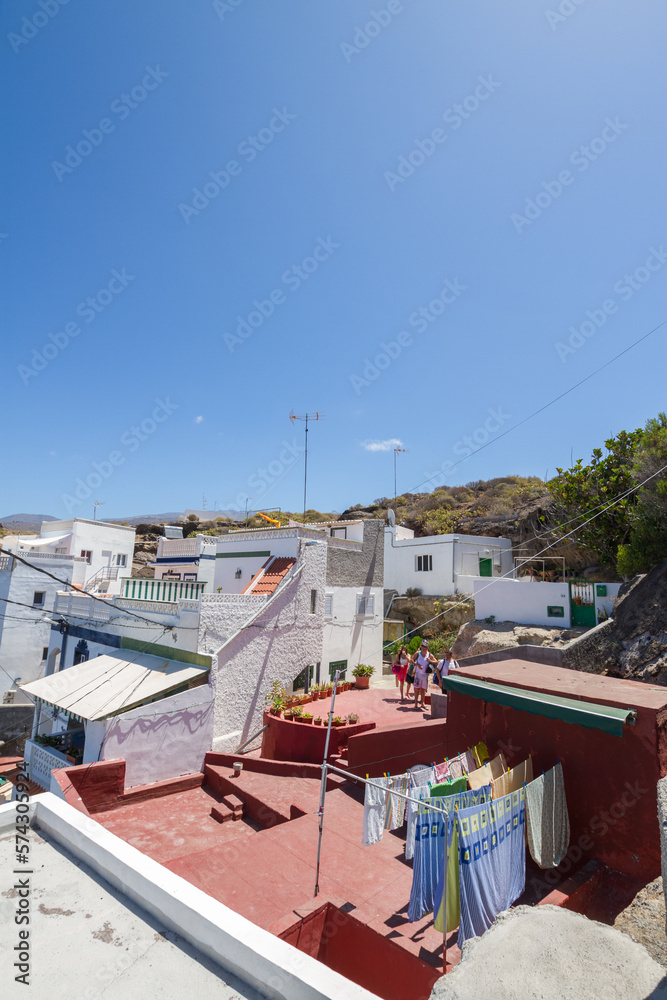Views of the houses of a typical seaside village on the coast of Tenerife, white houses, seaside village in the background. La Caleta, Tenerife, Canary Islands Spain.