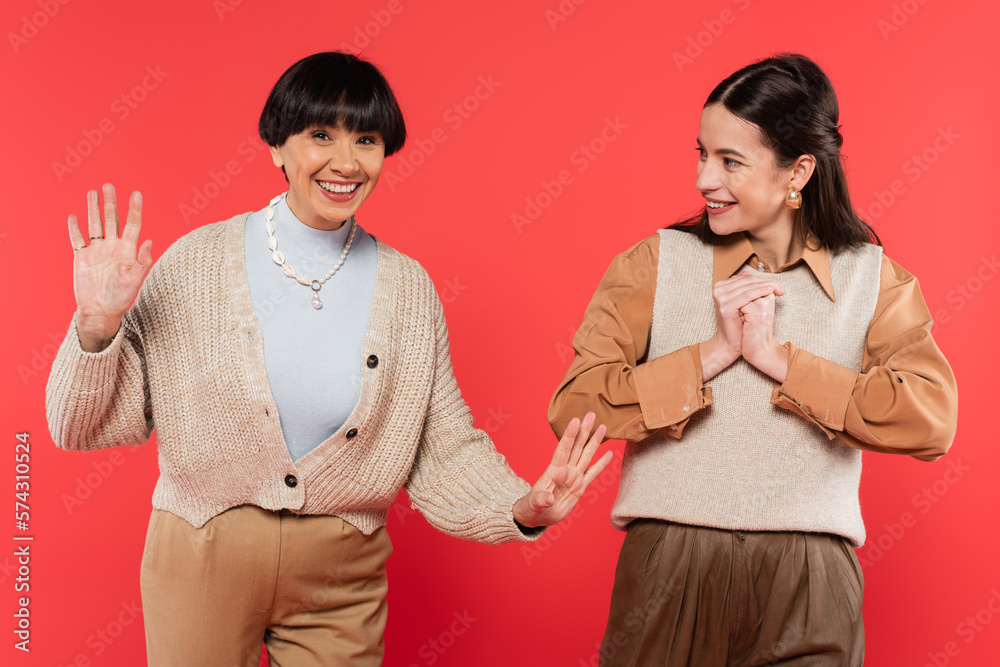 Φωτογραφία cheerful asian daughter in stylish clothes looking at excited mother waving hand