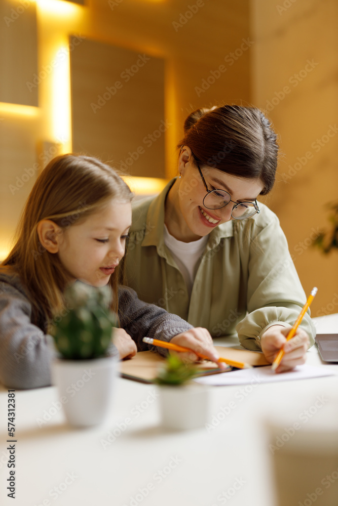 Back to school, individual lesson with a child. Vertical portrait of smiling teacher and student. Back to school, individual lesson with a child. Vertical portrait of smiling teacher and student.
