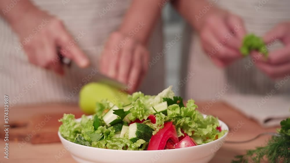 proper nutrition, elderly man together with his old wife prepare delicious fresh vegetable salad in kitchen, close-up proper nutrition, elderly man together with his old wife prepare delicious fresh vegetable salad in kitchen, close-up
