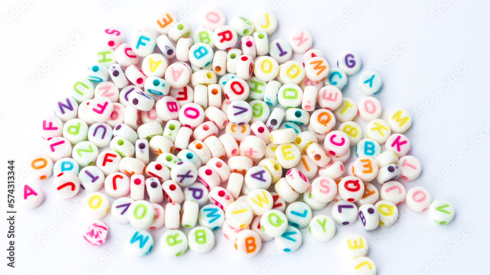 Collection of colourful beads blocks to make handmade jewellery bracelet names. heap of multi colored beads in street shop. Alphabets in kinder garden school for kids.