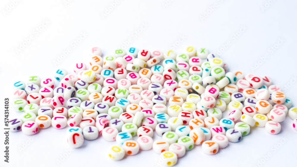 Collection of colourful beads blocks to make handmade jewellery bracelet names. heap of multi colored beads in street shop. Alphabets in kinder garden school for kids.