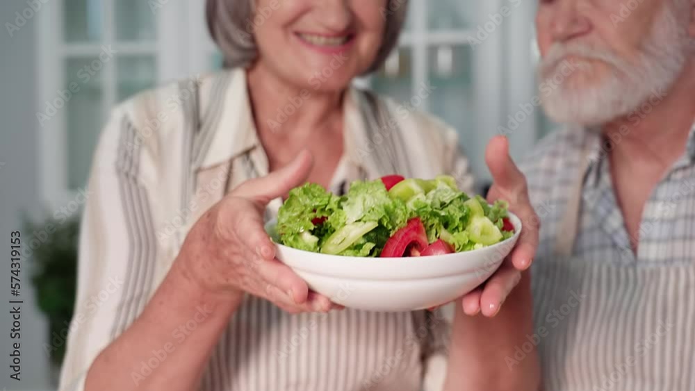 proper nutrition, portrait of an elderly couple with a fresh vegetable salad in their hands, smiling and looking at camera proper nutrition, portrait of an elderly couple with a fresh vegetable salad in their hands, smiling and looking at camera