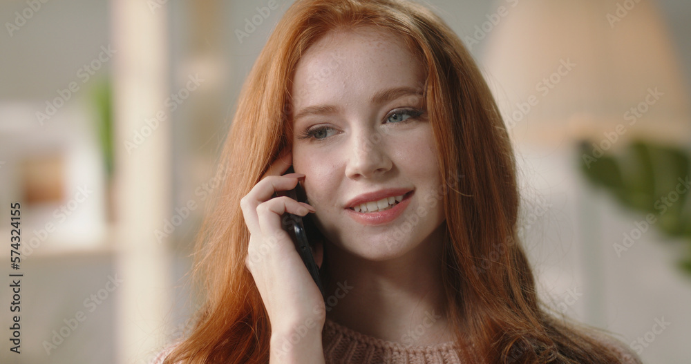Informal Call. Happy young ginger woman calling her friend, talking and asking about something, woman sit at home hold smartphone talks to client distantly, provide help by phone call Informal Call. Happy young ginger woman calling her friend, talking and asking about something, woman sit at home hold smartphone talks to client distantly, provide help by phone call
