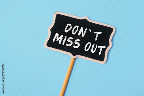 Don't miss out - text on a small chalkboard on a blue background. Top view. Life and business motivational inspirational concept