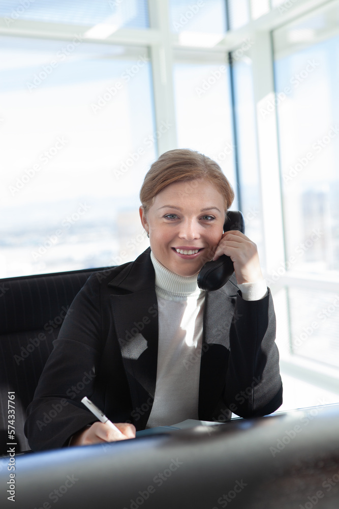 Portrait of young woman with phone in office environment