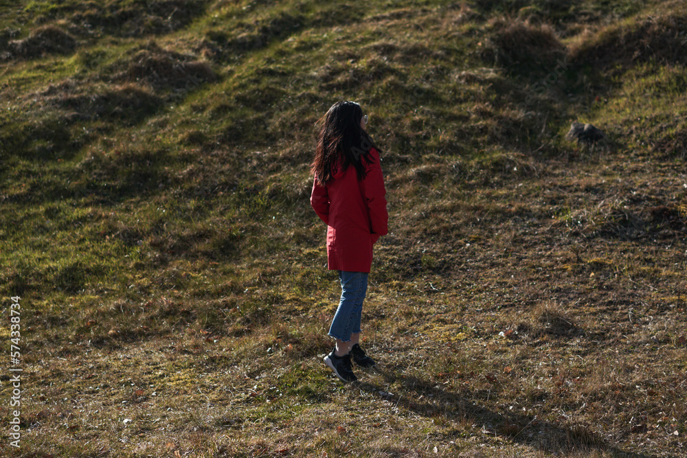 Fototapeta premium A girl enjoying the sunset, dancing around on the hill