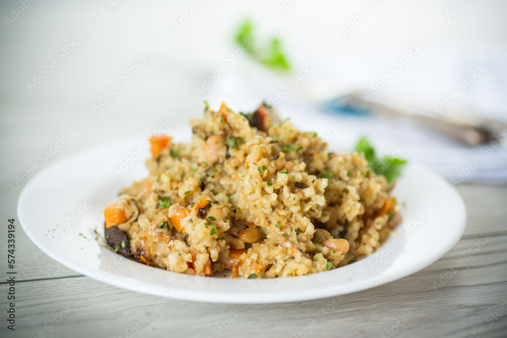 cooked bulgur with vegetables, carrots and dried mushrooms in a plate . cooked bulgur with vegetables, carrots and dried mushrooms in a plate .