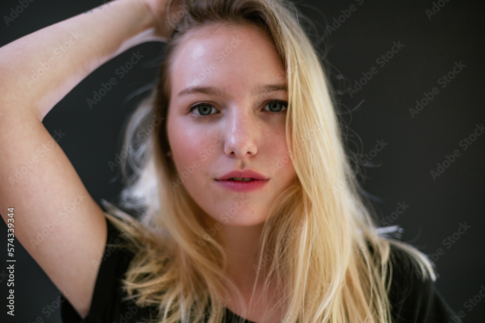 Beautiful young caucasian girl on dark background. Young blond hair female fashion model on black background. Fashion photoshoot. Beautiful young caucasian girl on dark background. Young blond hair female fashion model on black background. Fashion photoshoot.