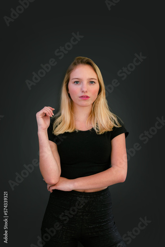 Beautiful young caucasian girl on dark background. Young blond hair female fashion model on black background. Fashion photoshoot.