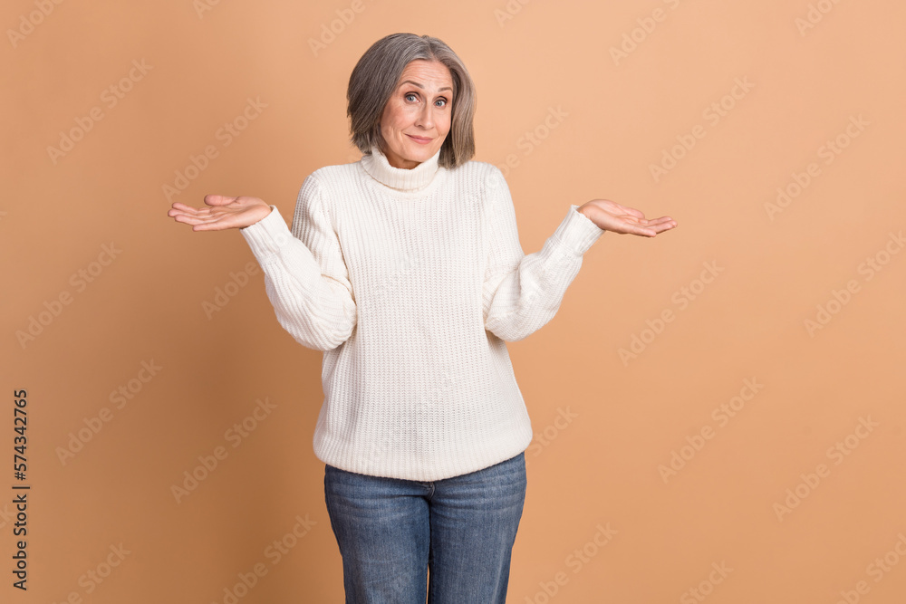 Photo of adorable funny woman wear knitted pullover rising arms shrugging shoulders isolated beige color background Photo of adorable funny woman wear knitted pullover rising arms shrugging shoulders isolated beige color background