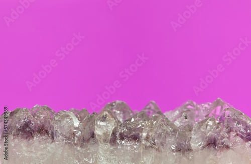 Light pale colored Amethyst quartz crystals in raw mineral form on a plain purple background. Conceptual image with copy space.  photo