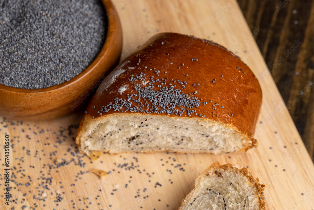 Poppy seeds and a bun with poppy seeds on the table