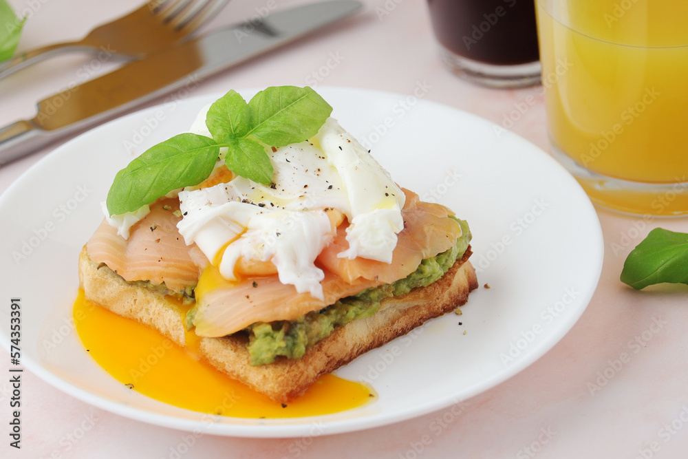 Breakfast with a sandwich with poached egg and avocado