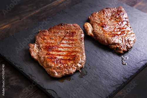 Obraz na płótnie Grilled minute steak of marbled beef on a stone slate board, close up w salonie