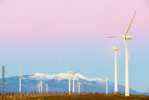 Wind turbine generators for renewable electricity production and snow mountain photo