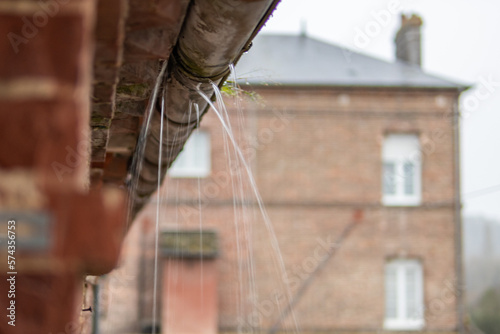 a gutter on a building, an old drainpipe close-up, water flows through rotten metal, there is a place for an inscription