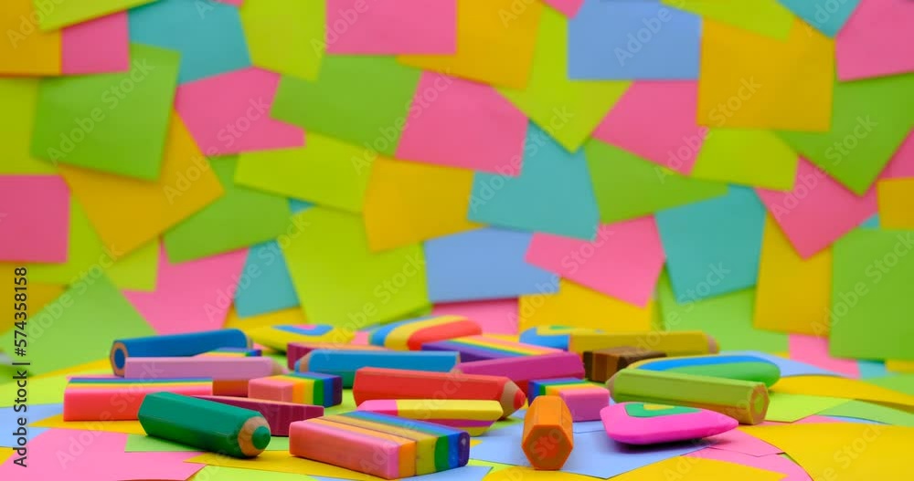 various shapes and colors of erasers arranged on a rotating table with multicolored paper sticky notes on background various shapes and colors of erasers arranged on a rotating table with multicolored paper sticky notes on background